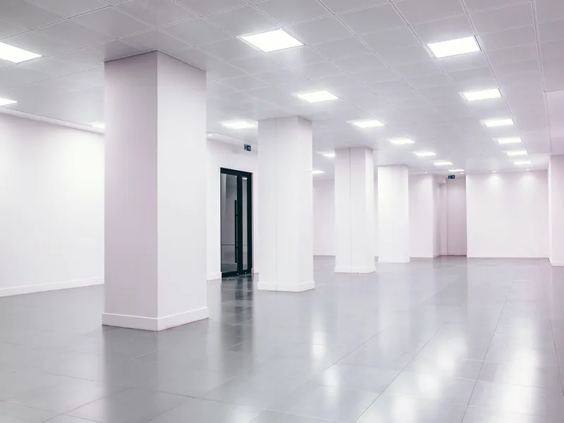 Hall au plafond démontable : dalles lisses blanches sur ossature apparente, luminaires encastrés